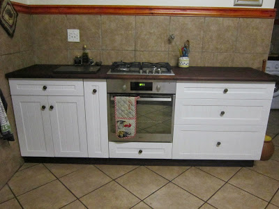 The farm style stove cupboard has a built-in gas stove and electric oven. Note the narrow spice drawer and the large drawers for pots and pans