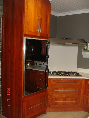 The gas stove and eye-high oven in rosewood cupboards  